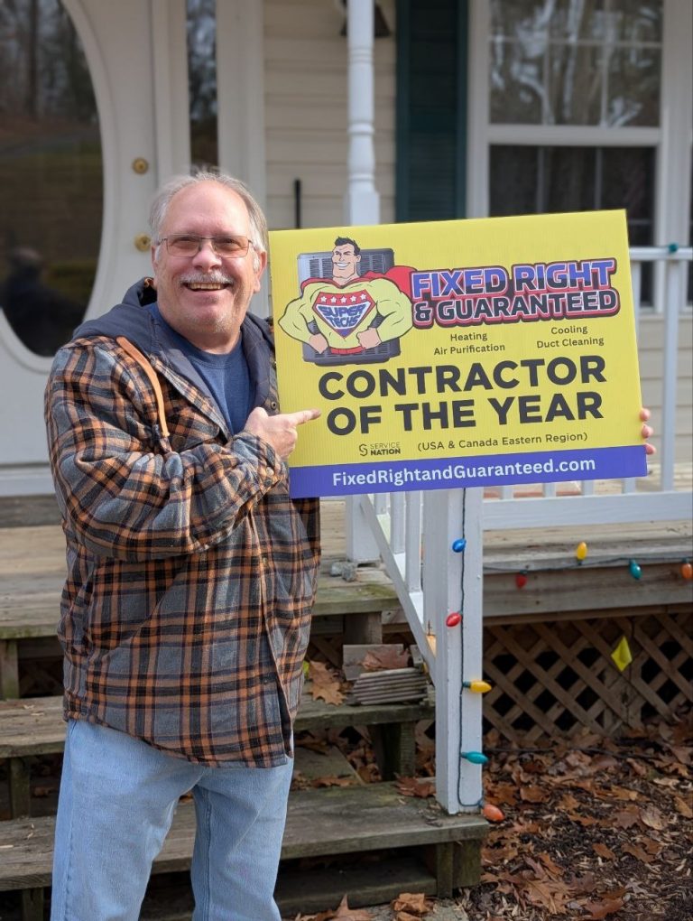 Man holding a sign that says Fixed Right & Guaranteed is the Contractor of the Year.