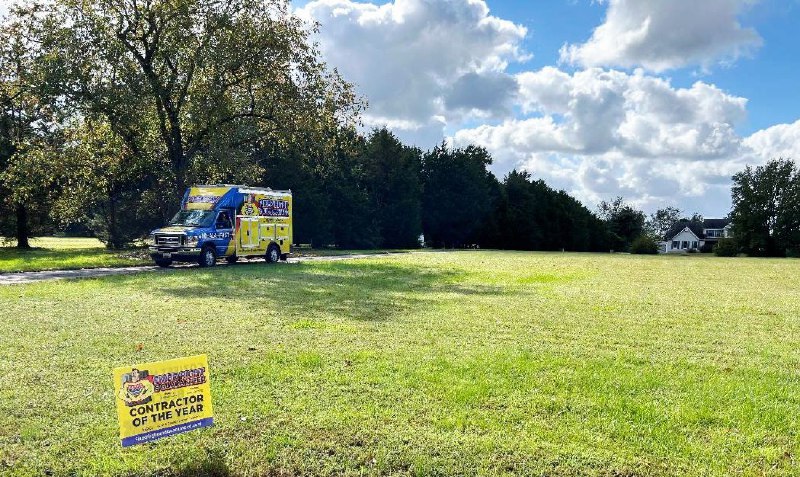 Fixed Right & Guaranteed trucked parked by an open green field.
